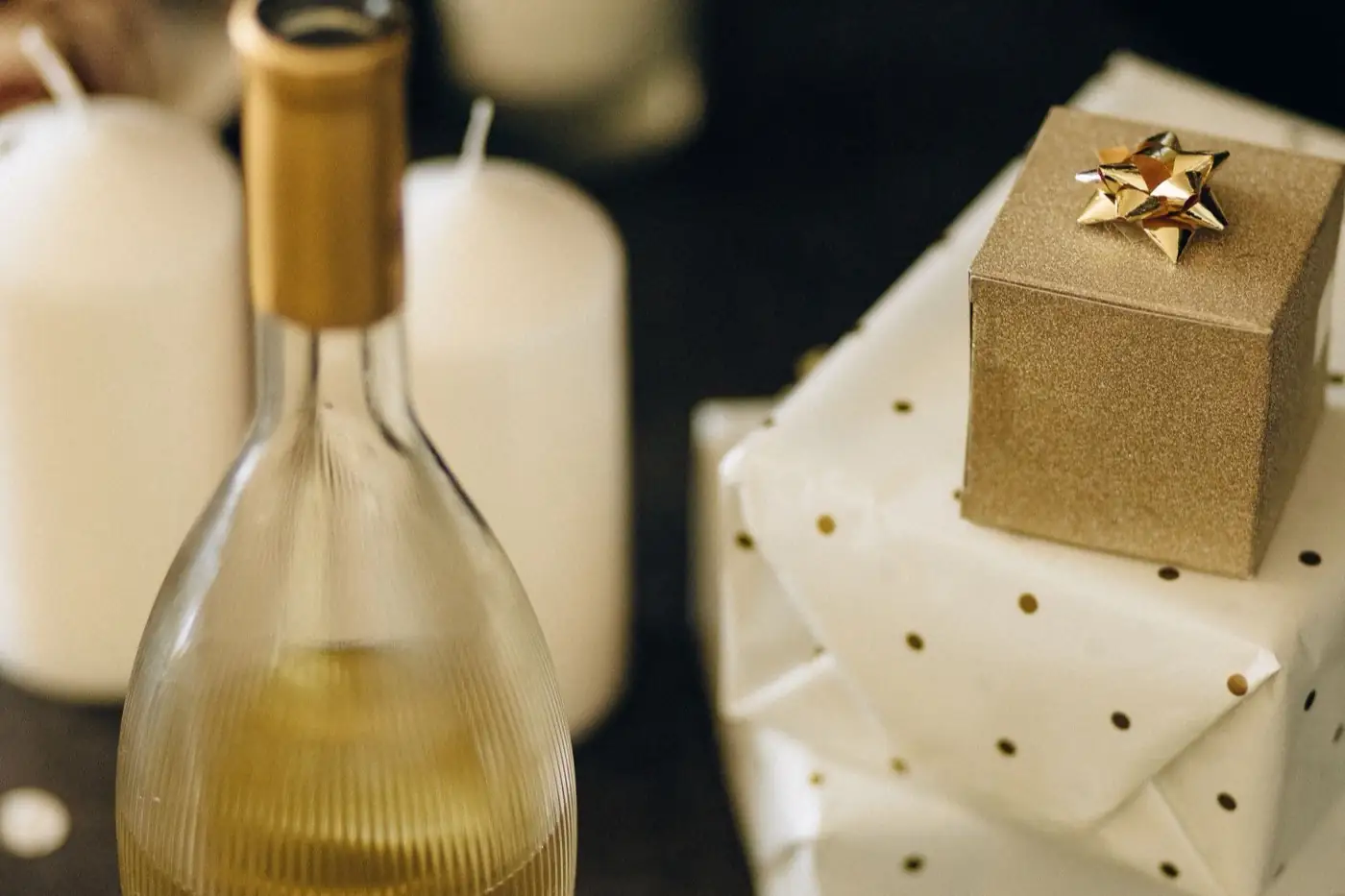 Une bouteille de vin à côté de paquets cadeaux.