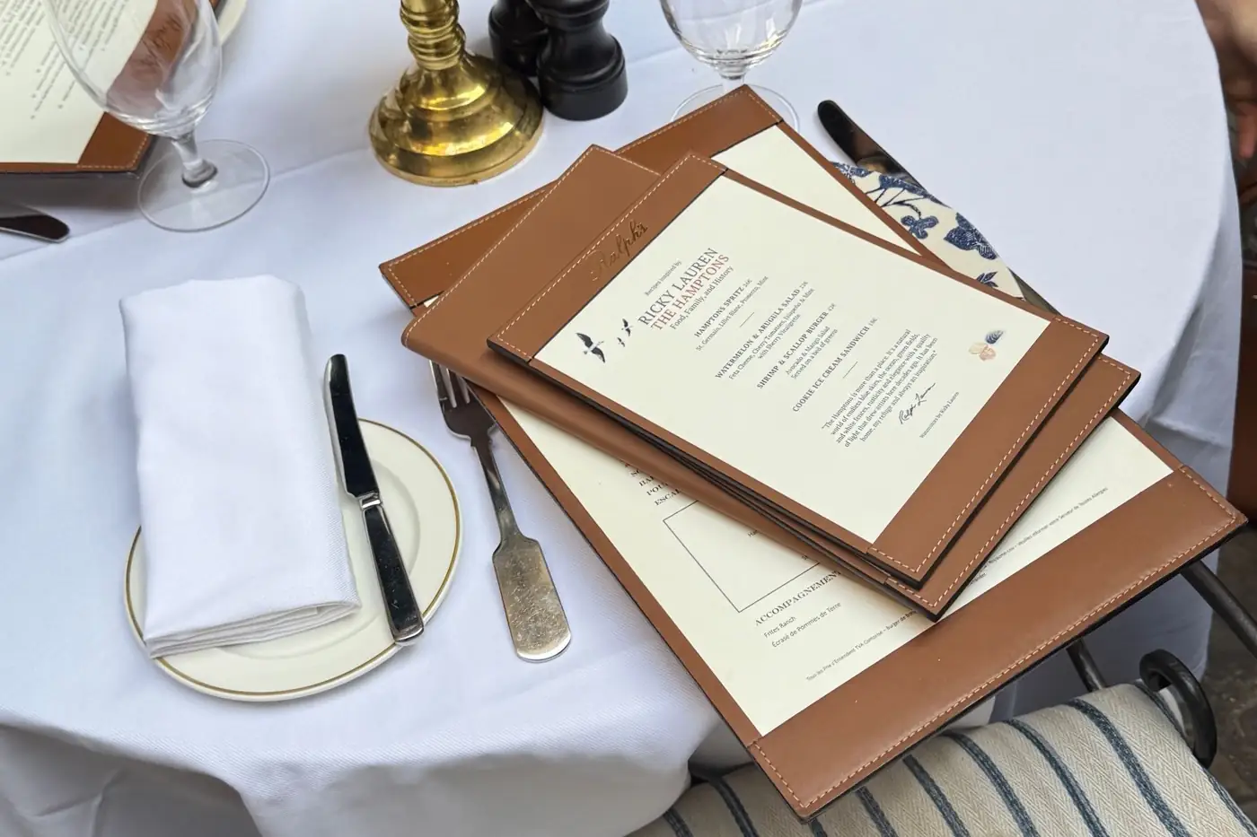 La carte d'un restaurant posée sur une table dressée.