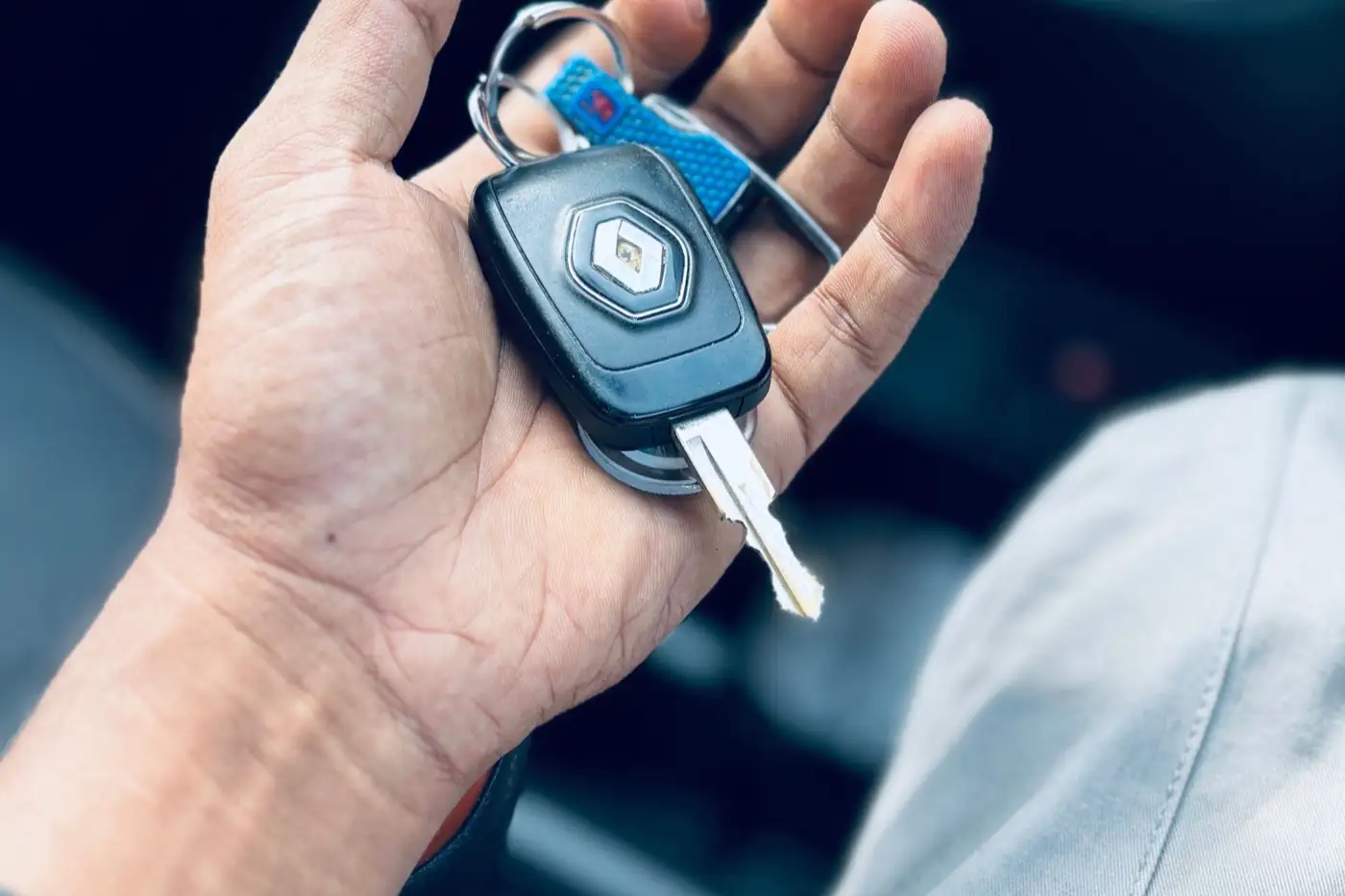 Une clé de voiture dans une main.