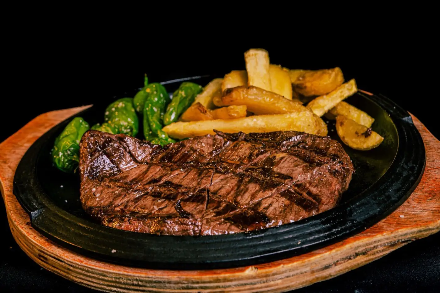 Une pièce de bœuf grillée servie avec des frites.
