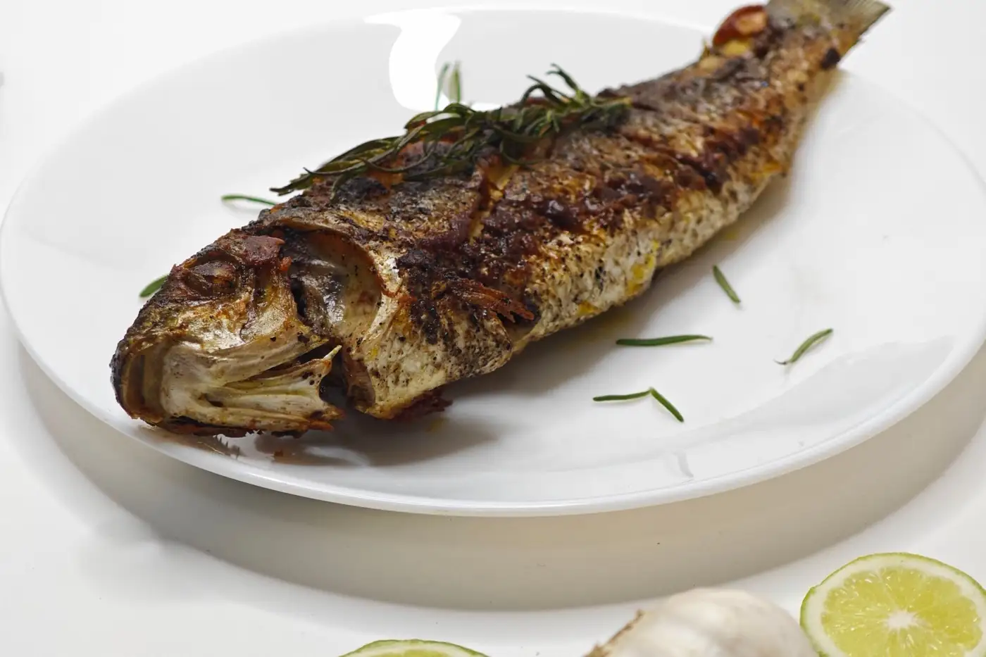 Un poisson entier grillé, servi à l'assiette.