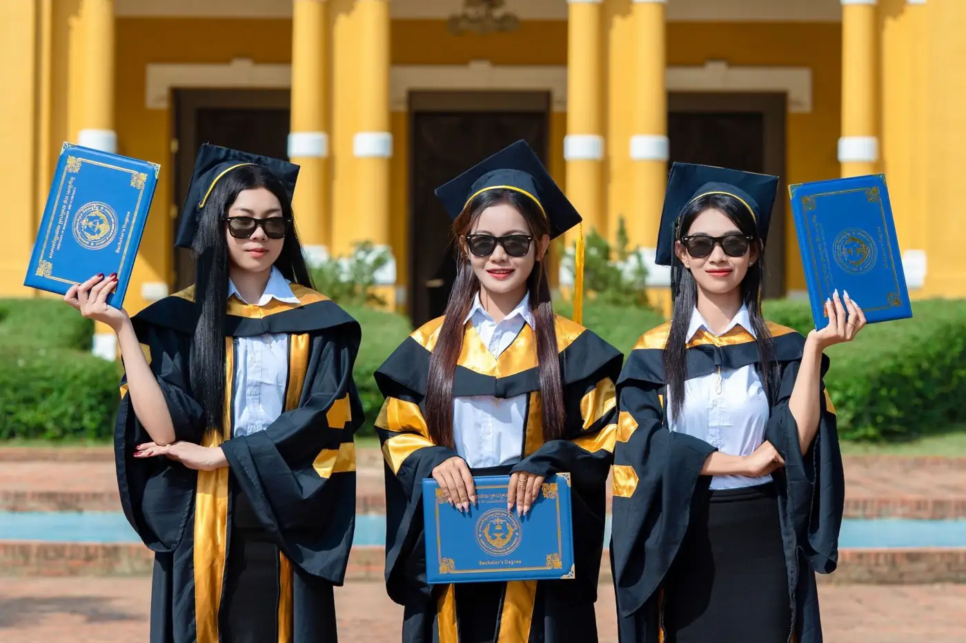 Des diplômés posent avec leur diplôme.