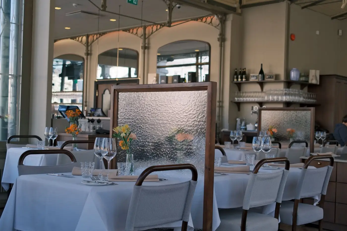 Une salle de restaurant gastronomique, nappes blanches.