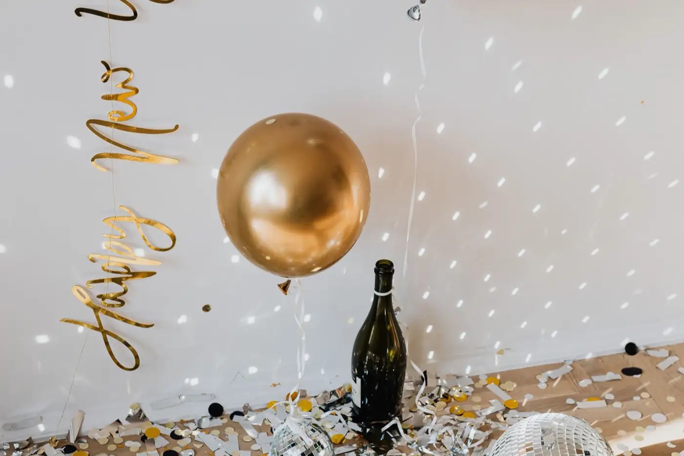 Une bouteille de bulles et un ballon doré pour le réveillon.