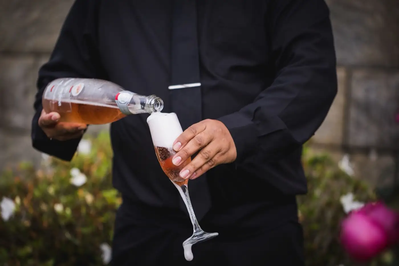 Un serveur verse des bulles dans une flûte.