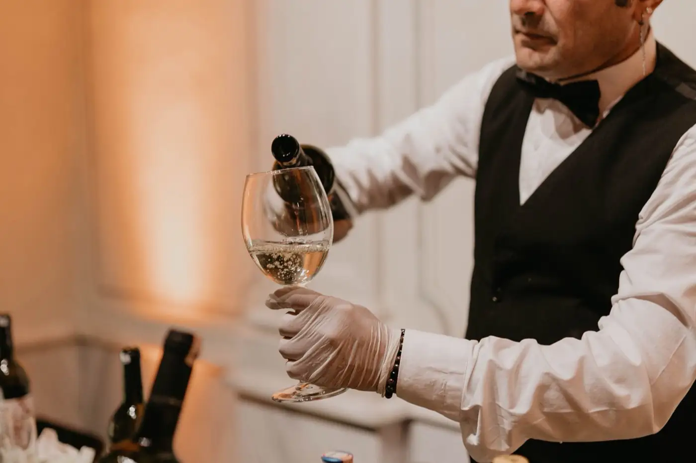Un serveur verse le vin dans un verre.