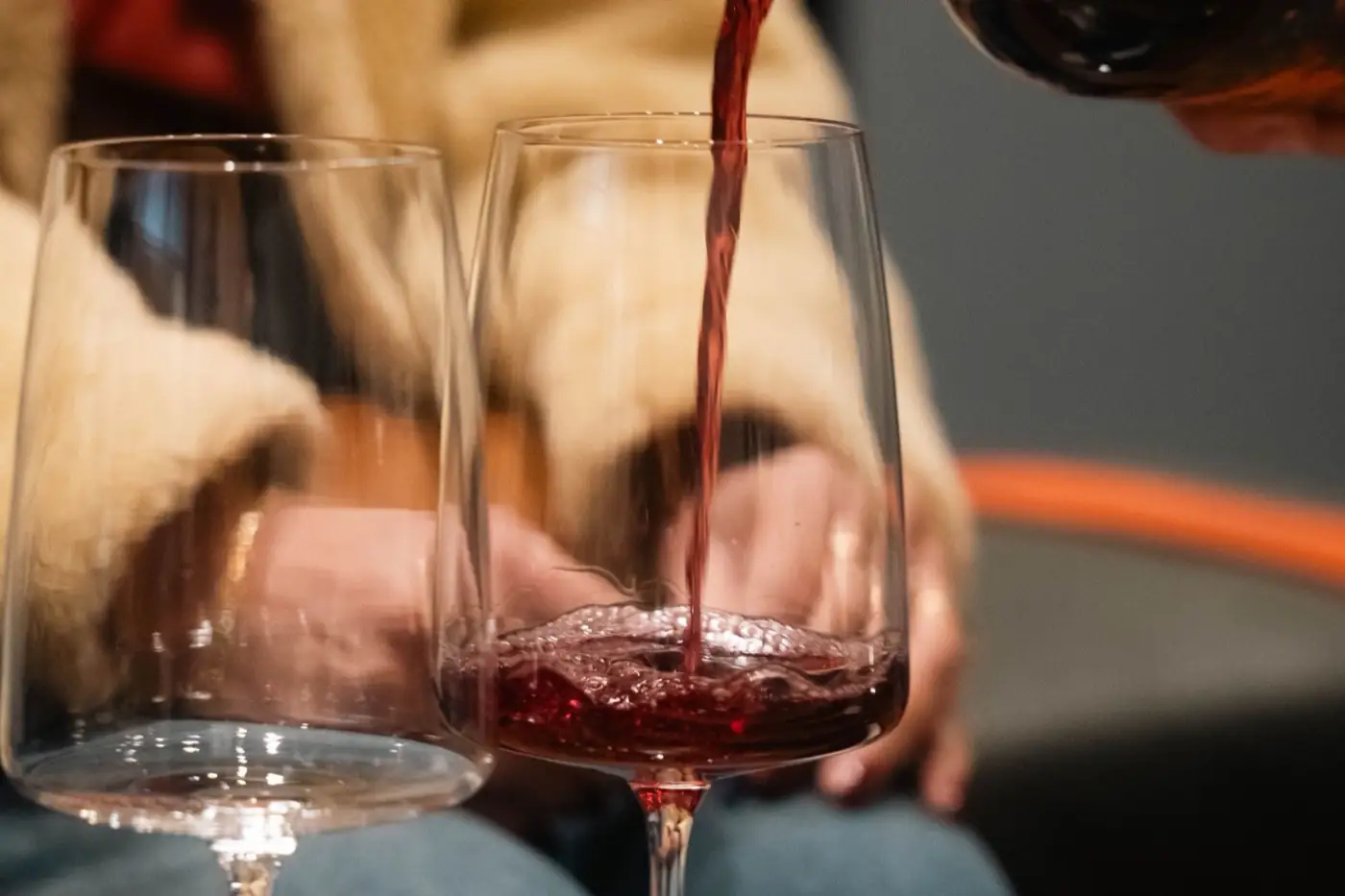 Un sommelier verse un verre de vin rouge.