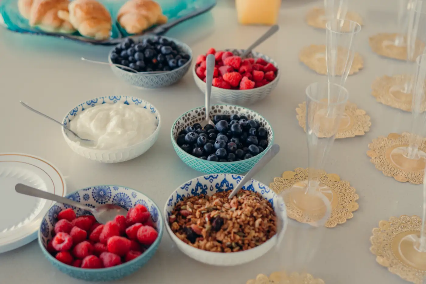 Une table de brunch garnie de coupelles et de viennoiseries.