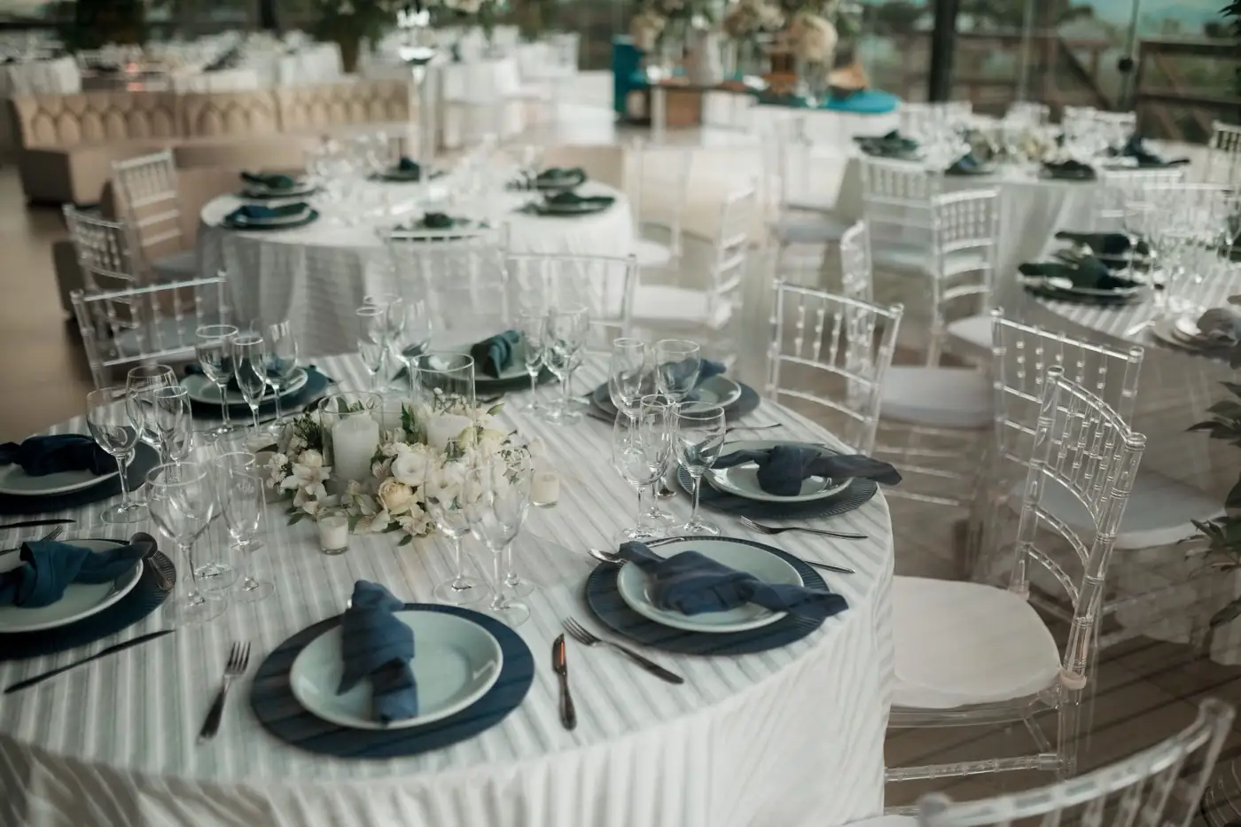 Des tables rondes dressées pour un grand repas.