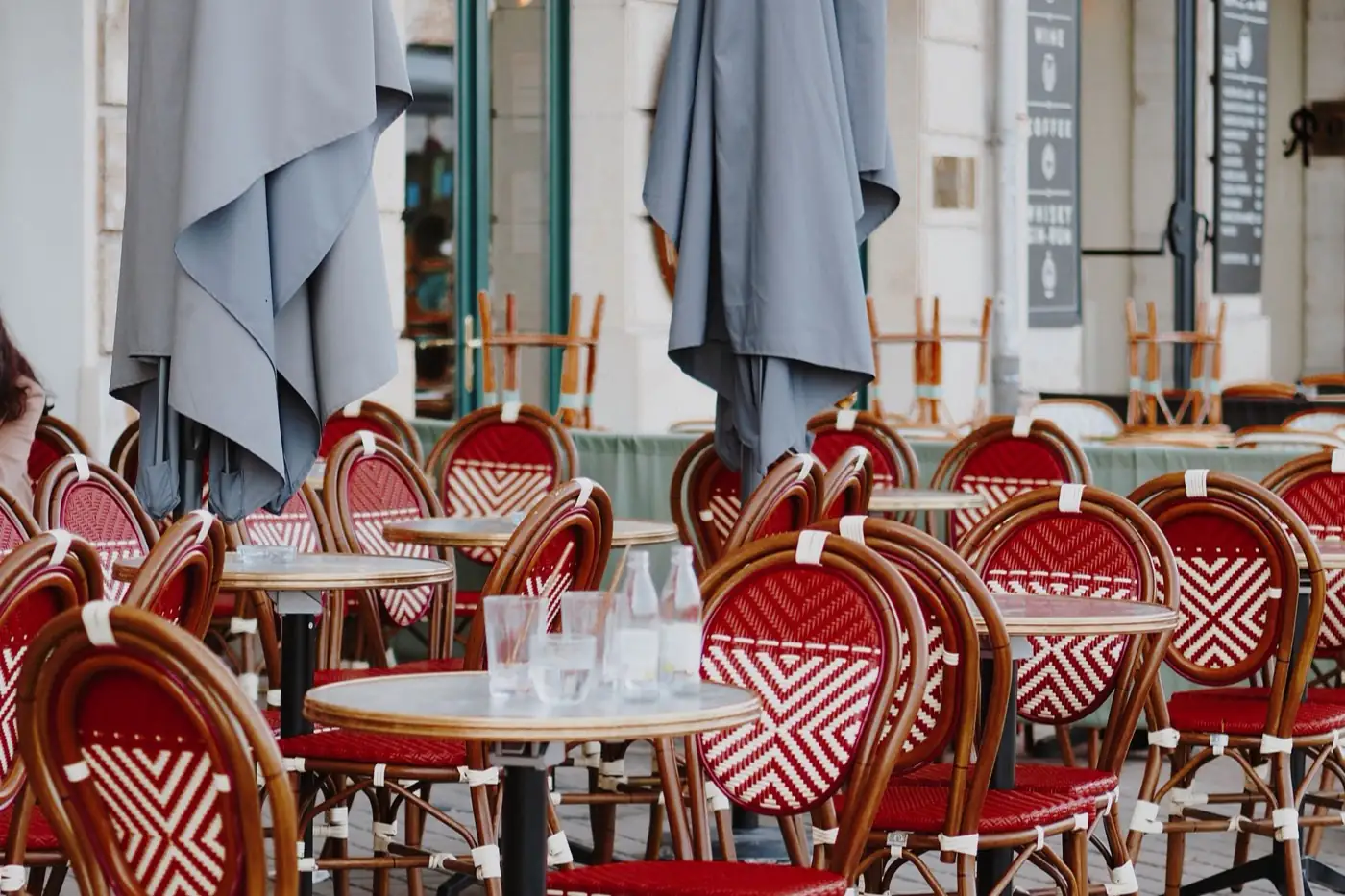 La terrasse d'un bistrot et ses chaises de rotin.