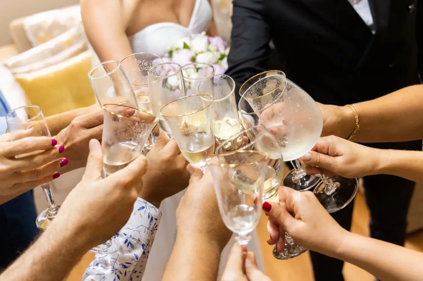 Des mains lèvent des coupes de champagne pour trinquer.