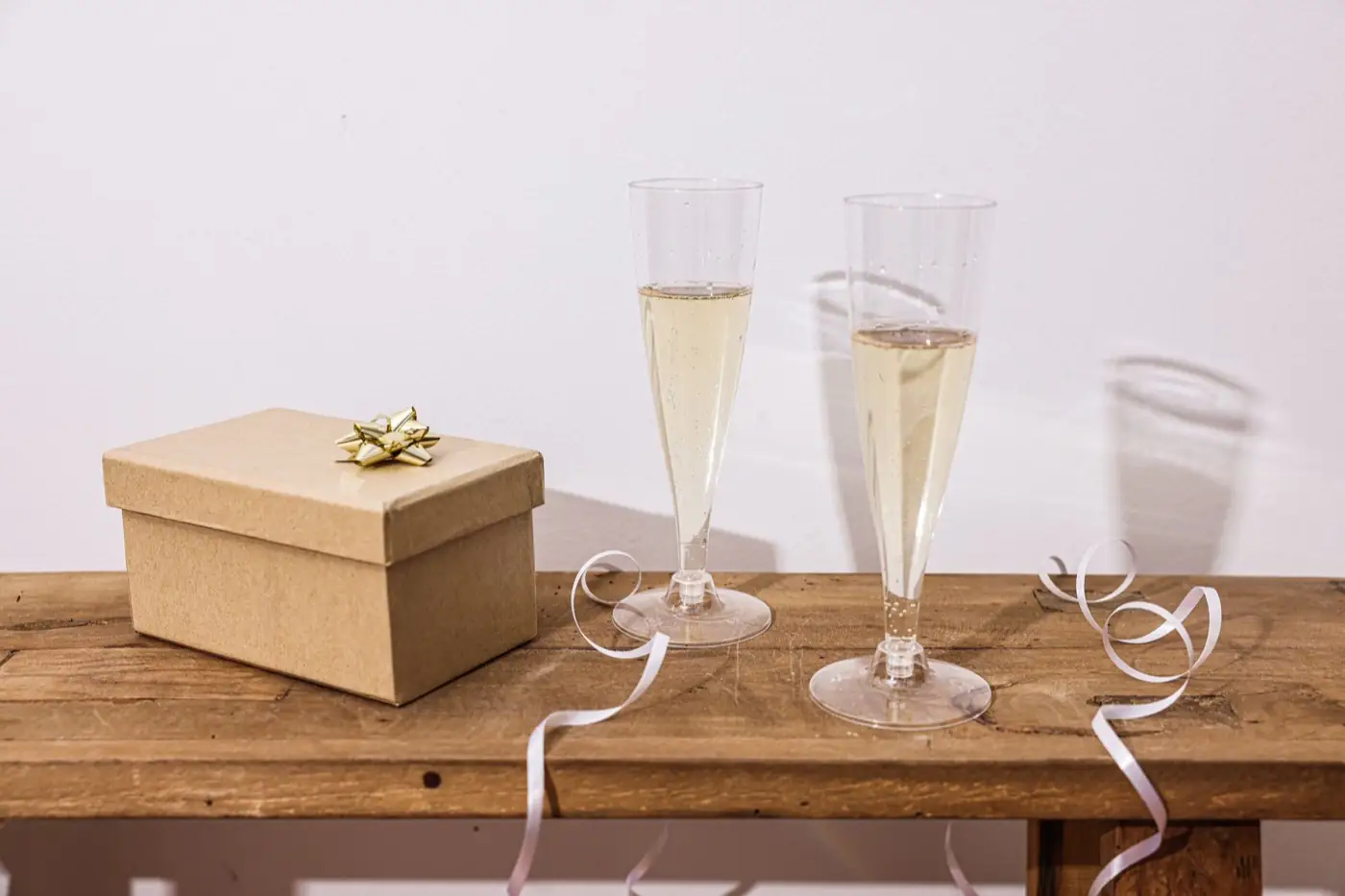 Deux flûtes servies et un coffret cadeau posés sur une table.