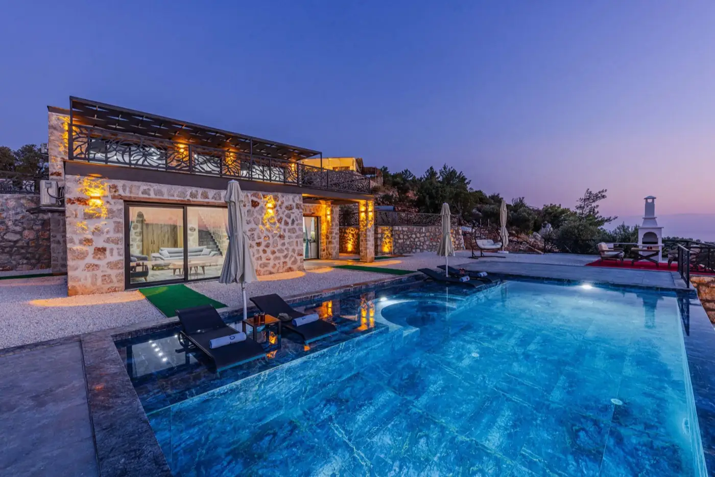 Une villa et sa piscine au crépuscule.